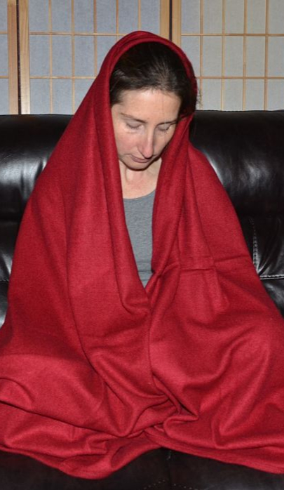 Empar is cloaked in a deep red Gesar meditation shawl, equally appropriate as a travel blanket